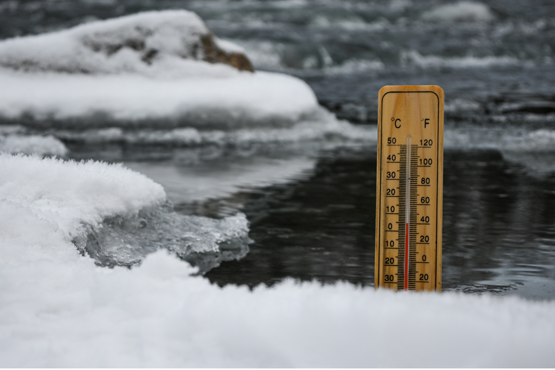 Thermometer in einem mit Eis bedecktem Gewässer 