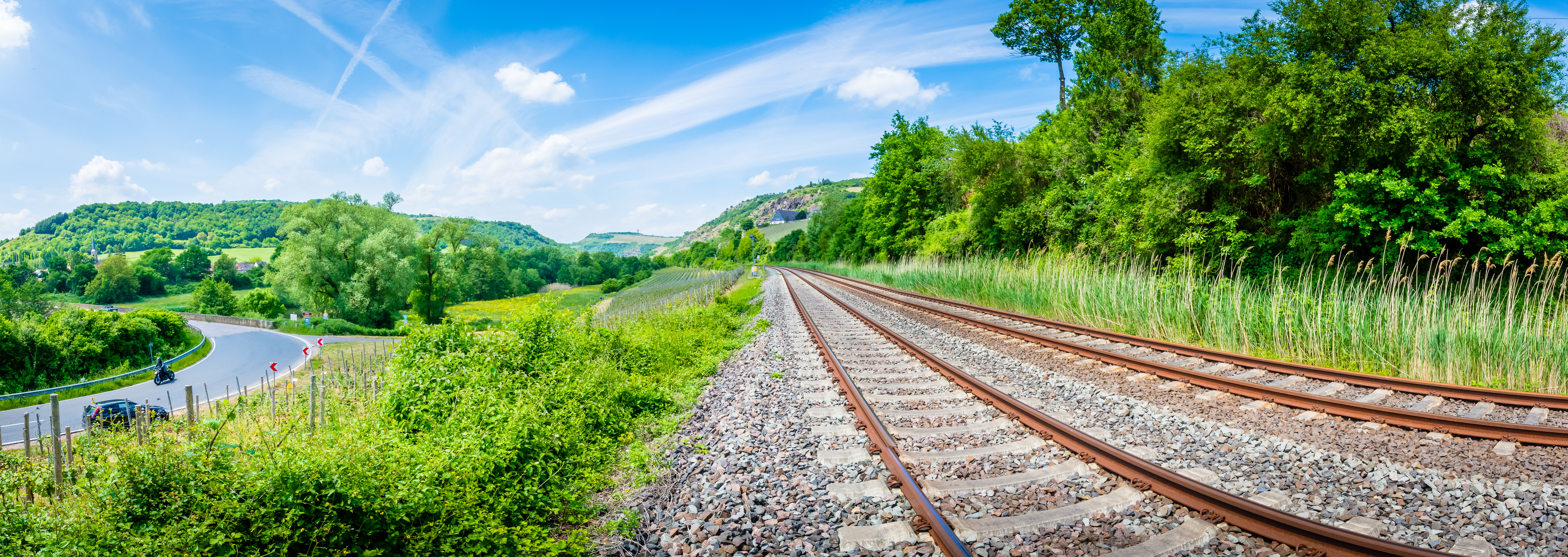 Schienengleise und Autoverkehr umgeben von Natur (Bildquelle: CPN – stock.adobe.com)
