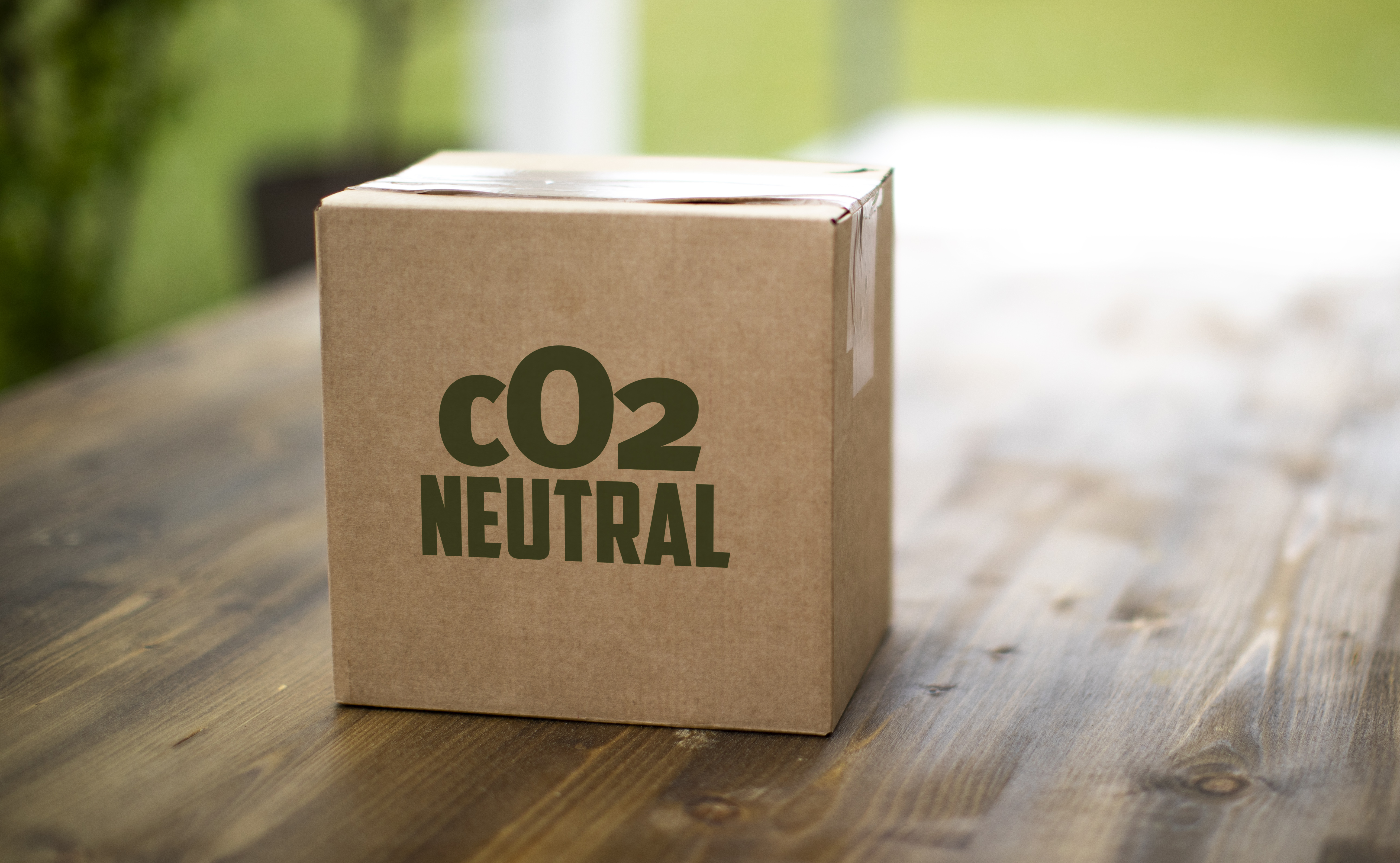 Das Bild zeigt ein Paket mit der Aufschrift CO2-neutral (Bildquelle: portraitfoto.in - stock.adobe.com)