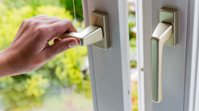 Person öffnet Fenster zum Lüften.
