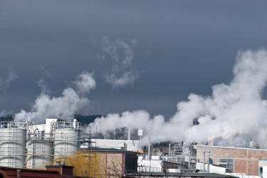 Aus einer industriellen Anlage ströhmt Abwärme in Form von Wasserdampf.