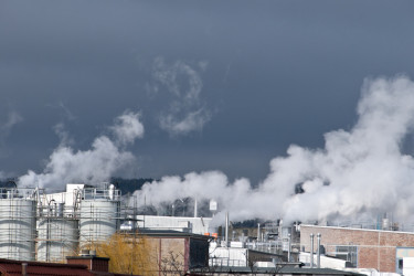 Aus einer industriellen Anlage ströhmt Abwärme in Form von Wasserdampf.