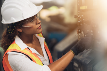 Produktion: Eine Frau bedient eine Maschine