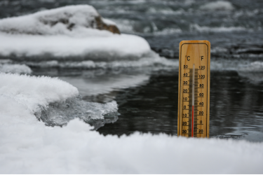 Thermometer in einem mit Eis bedecktem Gewässer