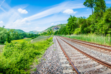 Schienengleise und Autoverkehr umgeben von Natur (Bildquelle: CPN – stock.adobe.com)