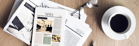 Zeitungen auf Holztisch mit Brille und Kaffeetasse (Quelle: sebra/stock.adobe.com)