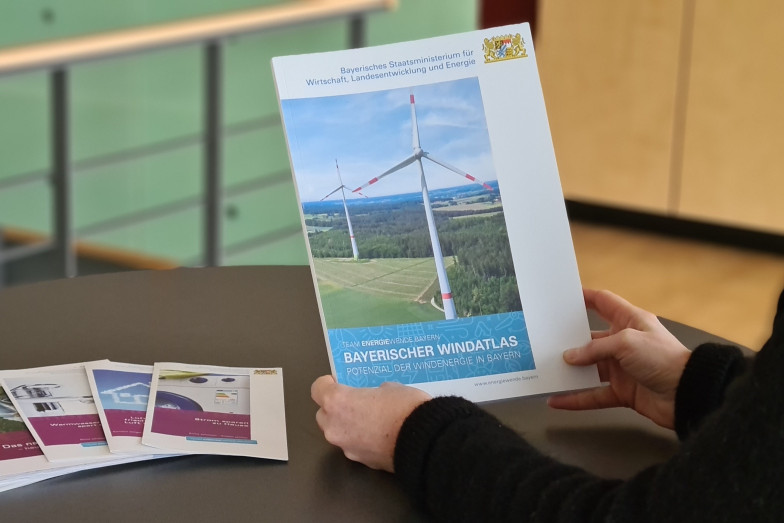 Person sieht sich eine Publikation an (Bildquelle: Energie-Atlas Bayern). Person sieht sich eine Publikation an.