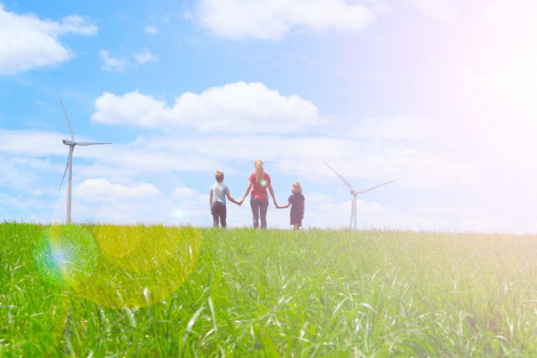 Familie auf einer Wiese mit Windrädern im Hintergrund (Bildquelle: M.studio - stock.adobe.com). Symbolbild für Akzeptanz
