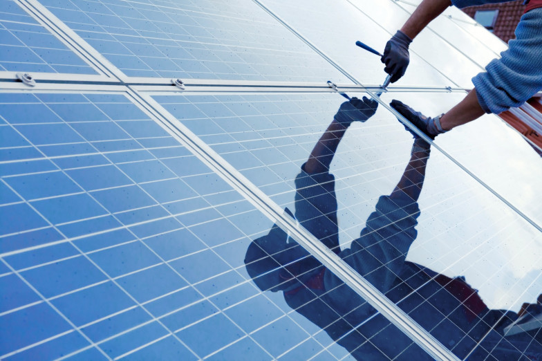 Ein Handwerker befestigt Photovoltaikmodule (Bildquelle: Fotolia.com - Simon Kraus) Ein Handwerker befestigt Photovoltaikmodule
