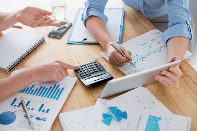 Person mit Diagrammen und Unterlagen an einem Tisch 