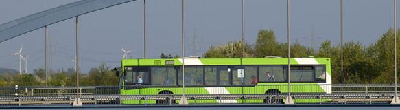 Ein öffentlicher Bus fährt über eine Brücke. Im Hintergrund sind Windräder zu sehen. (Quelle: Rolf Stumpf – Fotolia.com)