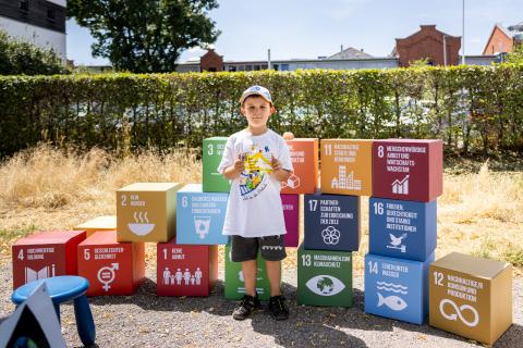 Ein Junge steht vor den SDG Würfeln (Quelle: Daggi Binder, maizucker.de)