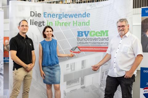 Drei Personen stehen vor der Info-Wand des Bundesverbands Gebäudemodernisierung (Quelle: Daggi Binder, maizucker.de)