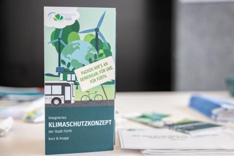 Der Flyer zum Klimaschutzkonzept der Stadt Fürth steht aufgerichtet auf einem Tisch (Quelle: Daggi Binder, maizucker.de)