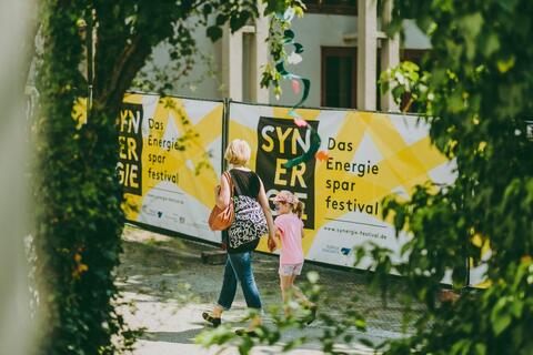 Besucherin mit Kind auf dem Deggendorf Synergie-Festival (Quelle: LfU)