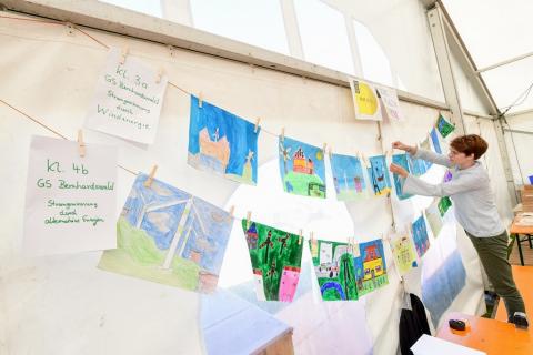 Eine Lehrerin präsentiert die Zeichnungen der Klassen 3 und 4 der Grundschule Bernhardswald an einer Wäscheleine. (Quelle: Tobias Hase) Die Kinder der Grundschule Bernhardswald kennen sich aus mit erneuerbaren Energien. (Quelle: Tobias Hase)