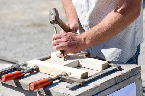 Ein Handwerker zeigt wie man mit Hammer und Meißel eine Hausnummer aus Stein schlägt. (Quelle: Tobias Hase) Kann man sich seine Hausnummer auch selber machen? Ein Handwerker zeigt wie es geht. (Quelle: Tobias Hase)