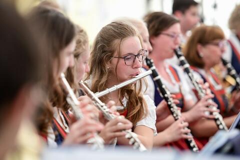 Eine Querflöterin der Blaskapelle Bernhardswald spielt inmitten ihrer Orchesterkolleginnen. (Quelle: Tobias Hase)