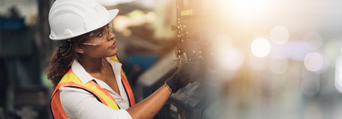 Produktion: Eine Frau bedient eine Maschine 