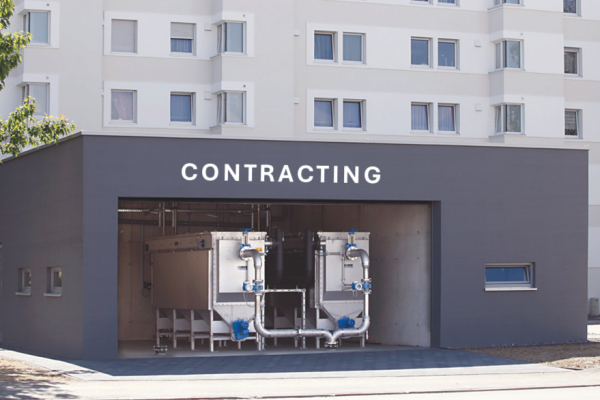 Gebäude mit geöffnetem Rolltor, welches die Ansicht auf die beiden externen Abwasserwärmetauscher frei gibt. 