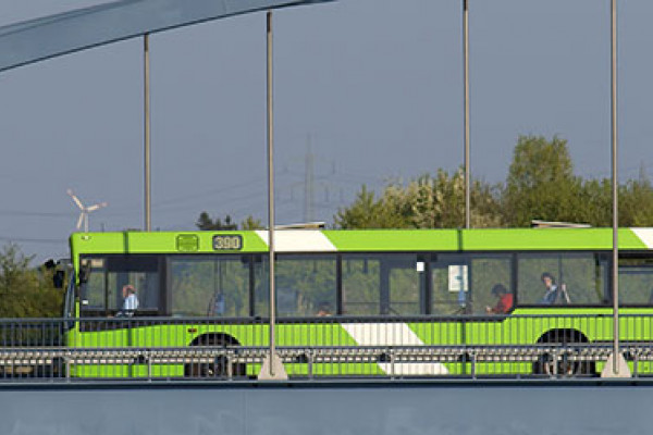 Ein öffentlicher Bus fährt über eine Brücke. Im Hintergrund sind Windräder zu sehen. (Quelle: Rolf Stumpf – Fotolia.com) Ein öffentlicher Bus fährt über eine Brücke. Im Hintergrund sind Windräder zu sehen. (Quelle: Rolf Stumpf – Fotolia.com)