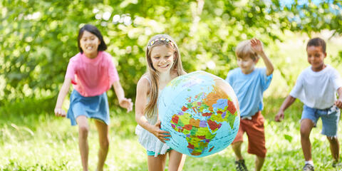 Kinder spielen mit Luftballons auf einer Wiese in der Sonne (Bildquelle: Robert Kneschke  - stock.adobe.com).