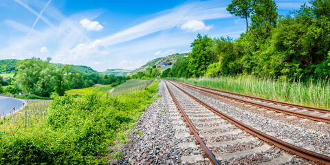 Schienengleise und Autoverkehr umgeben von Natur (Bildquelle: CPN – stock.adobe.com)