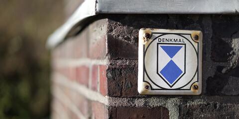 Schild Denkmalschutz an einer Mauer